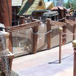A themed waiting cue line, using mesh netting for a barrier railing.