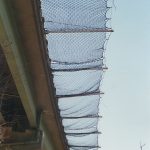 Safety netting installed on outrigger poles along an elevated highway.