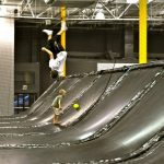 A child does a backflip in a trampoline park.