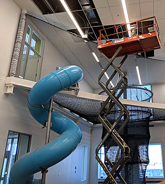 A climbing playscape being installed in a children's museum.