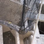 Debris safety netting on construction project catches heavy load of debris
