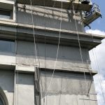 Facade netting conforms to the shape of architectural details on a building during reconstruction.