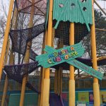 a climbing net leads up to a net bridge at The Monster Clubhouse at Sesame Place