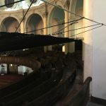Debris netting suspended over the audience seating area in a church.