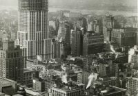 The Empire State Building during construction, raises far above the rest of the neighborhood.