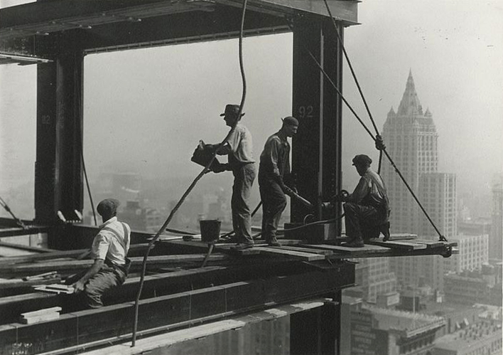 Workmen apply rivets to a beam of The Empire State Building.