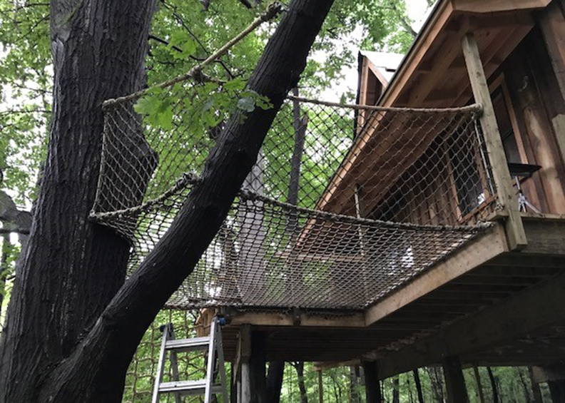A netted platform attached to a tree house.