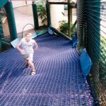 A boy on a climbing net ramp.
