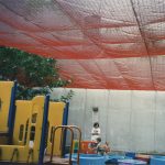 Debris safety netting suspended above a playground